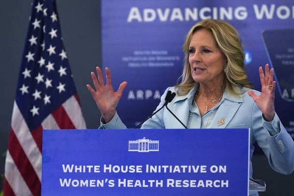 The First Lady gesturing at a podium with the text 